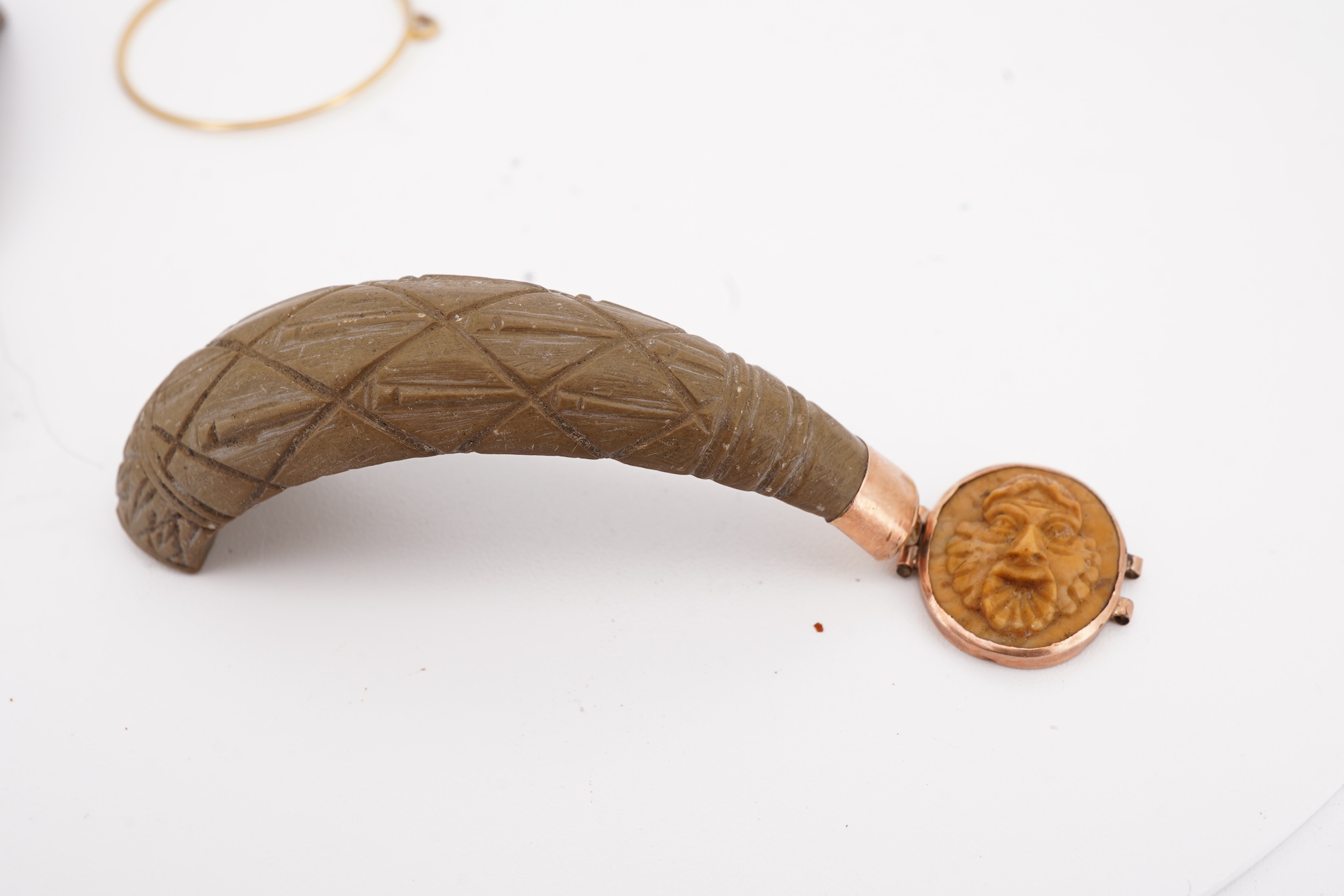 A collection of carved lava fragments, 19th century, once forming a bangle, the fragments variously carved with abstract floral motifs, lion's heads, and a theatrical mask, largest 6.2cm, Condition: fragmentary, but carv